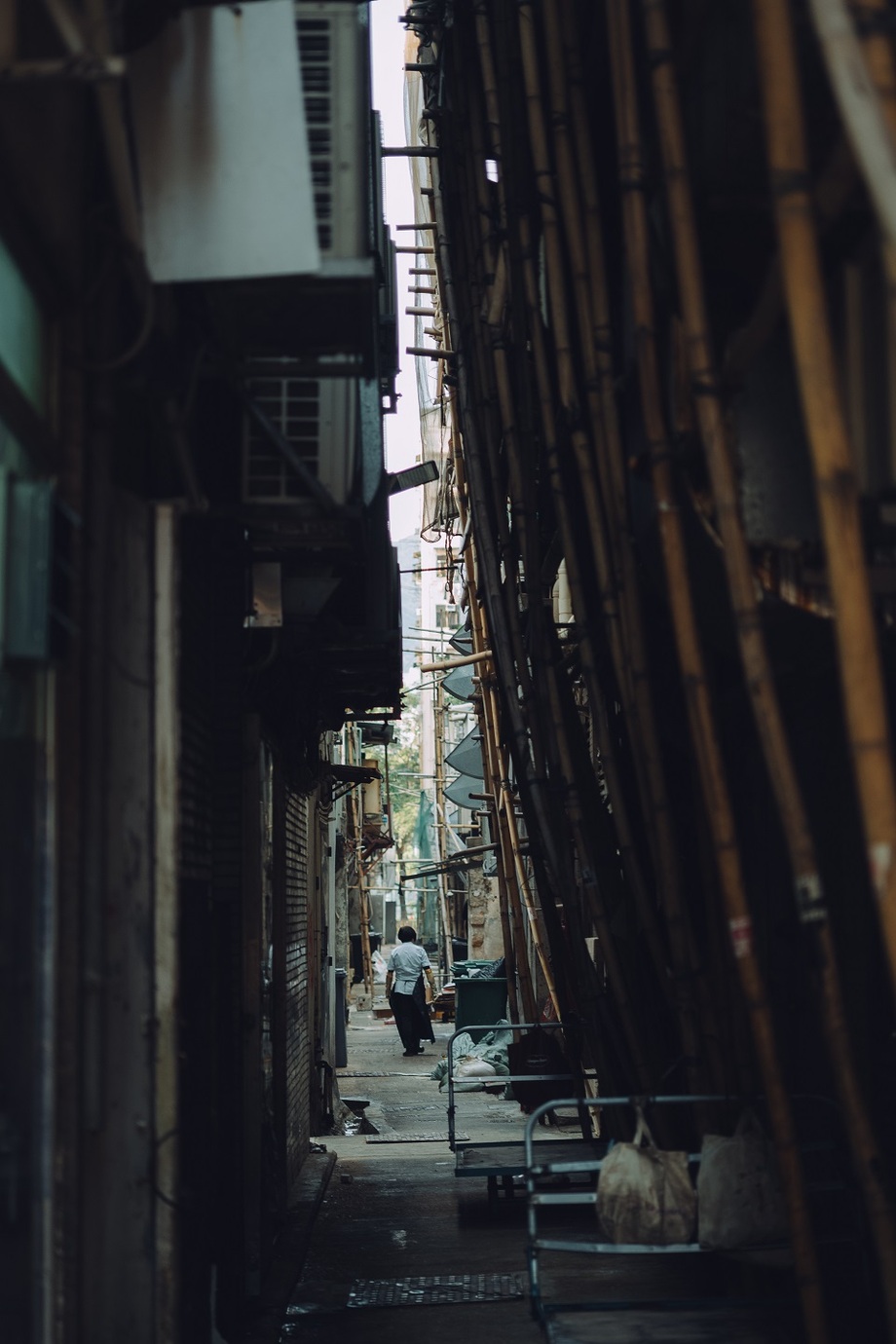 Leica M10-Pとアポ・ズミクロン M f2/50mm ASPH.を使用して香港の建物の隙間を歩いている人を撮影した写真