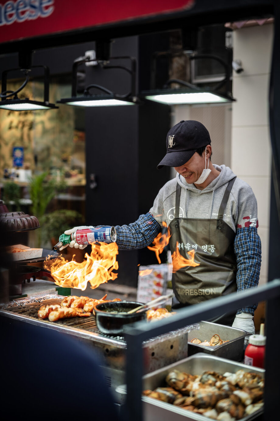 ライカM10-Pとアポ・ズミクロンM f2/50mmで韓国・明洞の出店で串焼きをする男性を撮影した写真